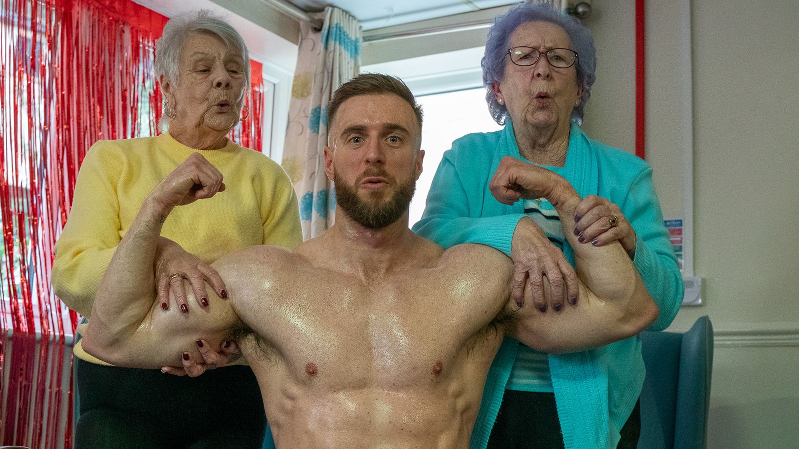 Residents Olwyn Smith (left) and Anne Hodgson with Dreamboys male stripper Max Hunter. Pic: Popular Care/PA