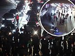 Anti-Trump protesters storm LA freeway and face off with police in riot gear during daylong demonstration against mass deportations