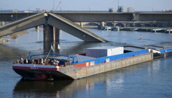 Ein Frachter fährt als erstes Schiff unter der teilweise eingestürzten Carolabrücke hindurch. Foto: Robert Michael/dpa