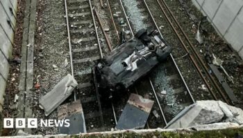 Travel chaos after car plummets on to railway line